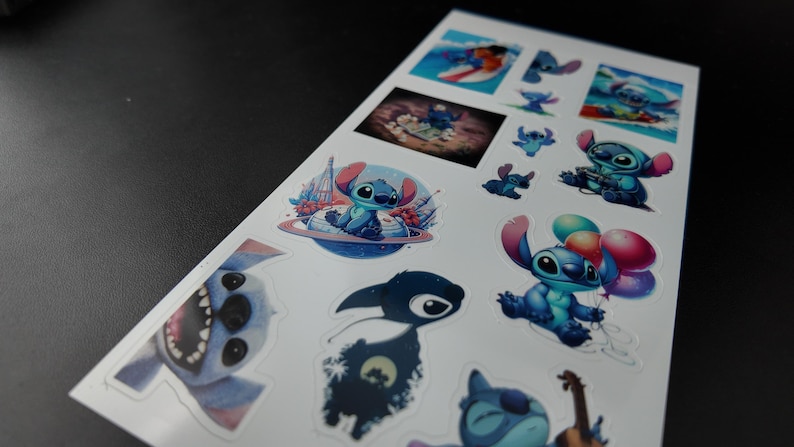 May include: A sheet of stickers featuring the character Stitch from the Disney movie Lilo & Stitch. The stickers depict Stitch in various poses, including surfing, holding balloons, and playing a ukulele. The stickers are in shades of blue, pink, and purple.