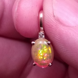 1.11 Carat Natural Ethiopian Opal with Accent Diamond set in a 14 karat solid yellow gold pendant, see 550.00 appraisal