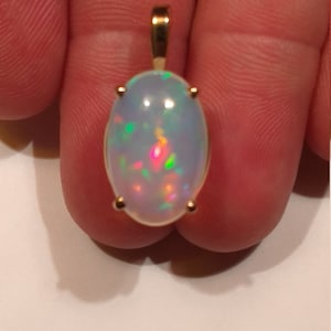 Huge 7 Carat Natural Ethiopian Opal Oval Cabochon set in a 14k Solid Yellow Gold Pendant see appraisal 2300.00