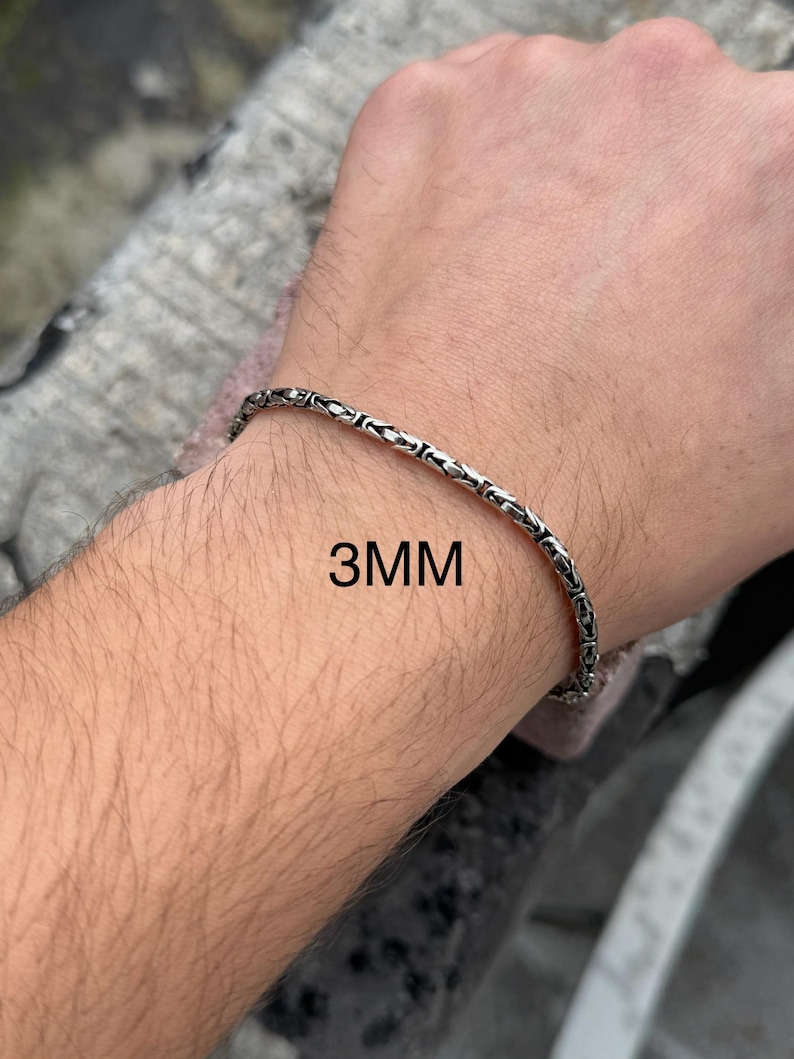 May include: A silver chain bracelet with a box chain design. The bracelet is 3mm wide.