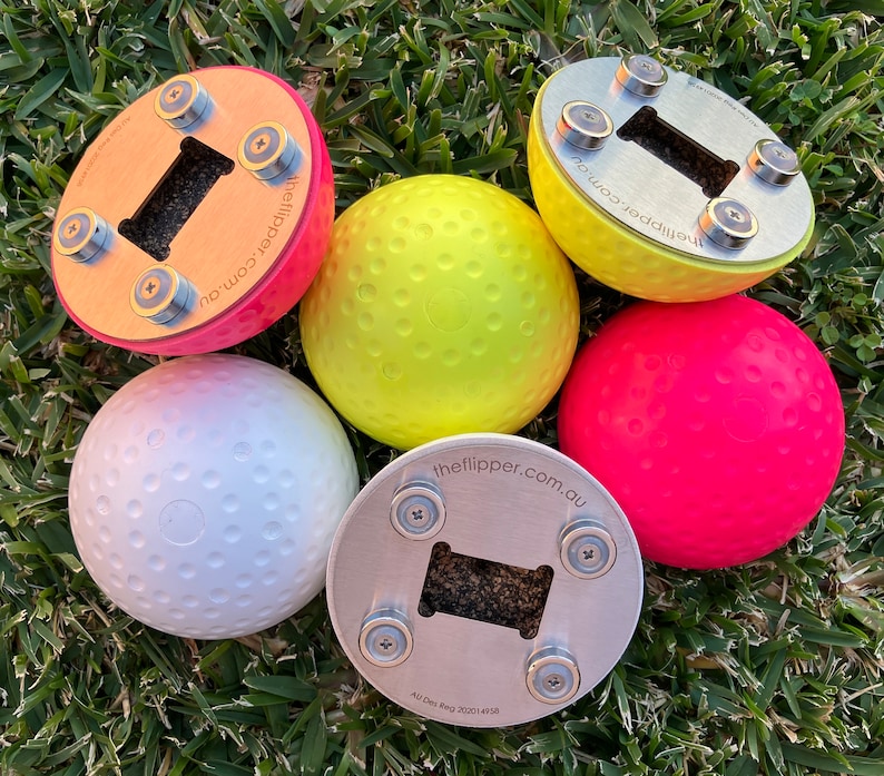 K&ouml;nnte beinhalten: F&uuml;nf runde B&auml;lle in verschiedenen Farben mit einer strukturierten Oberfl&auml;che. Jeder Ball hat eine magnetische Basis mit einem Flaschen&ouml;ffner. Die Basen sind aus Metall und Holz. Der Text "theflipper.com.au" ist auf den Basen aufgedruckt.