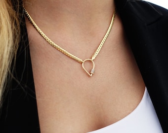 May include: A gold chain necklace with a teardrop-shaped pendant featuring a small cluster of diamonds.