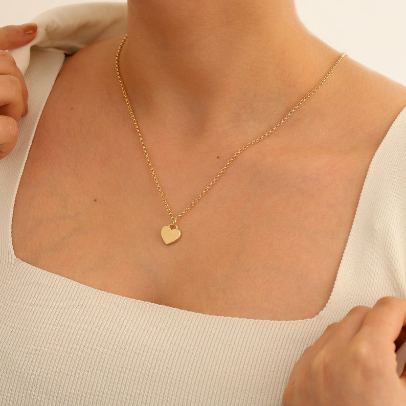 May include: A gold chain necklace with a small heart pendant.
