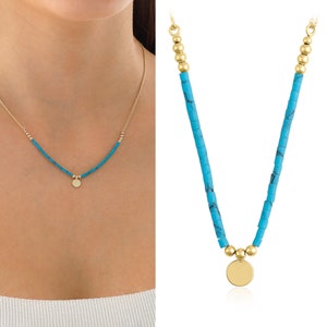 May include: A turquoise and gold necklace with a round pendant. The necklace is made of small turquoise beads and gold beads. The pendant is a large, round, gold disc.