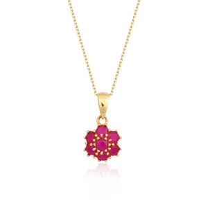 May include: A gold chain necklace with a pendant featuring a cluster of pink gemstones in a flower shape.