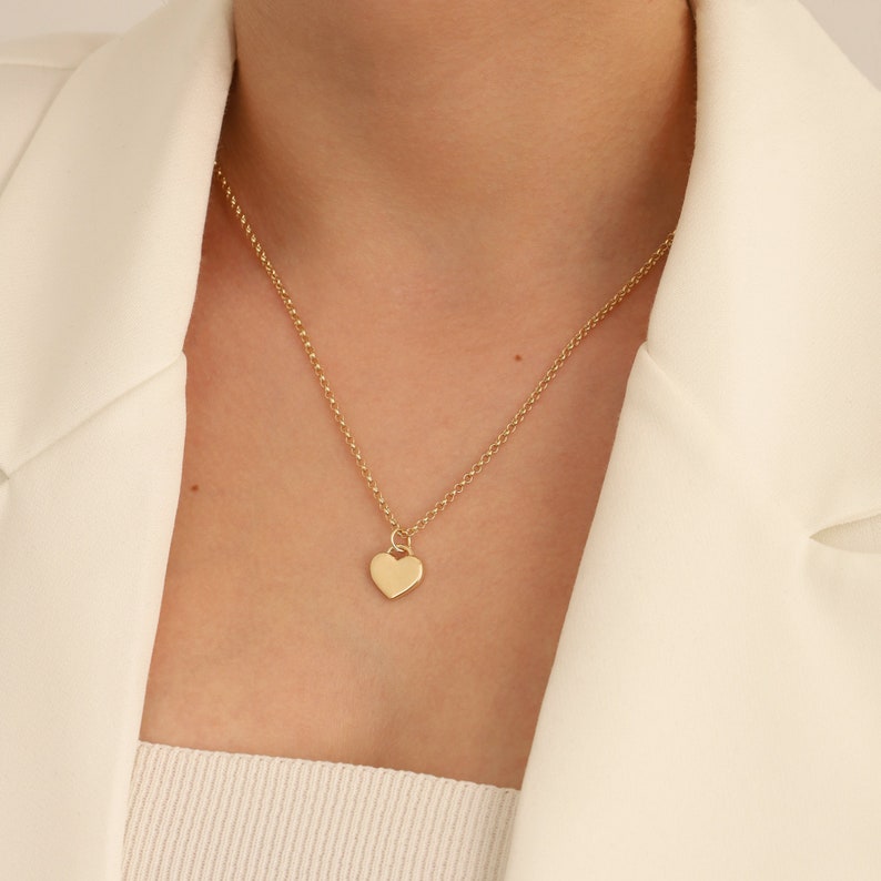 May include: A gold chain necklace with a small heart pendant.