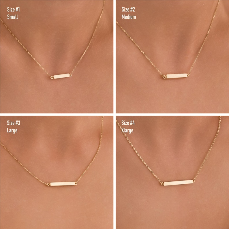 May include: Four gold necklaces with a horizontal bar pendant. The necklaces are shown in four different sizes: small, medium, large, and extra large. The necklaces are on a model's neck.