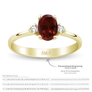 May include: A gold band ring with a red oval gemstone and two smaller white gemstones on either side. The ring has the inscription "D&S" on the inside of the band. The image includes text that reads "Personalized Engraving - Inside of Band - Up to 10-12 characters name, word or date".