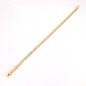 May include: A gold snake chain necklace with a clasp closure.
