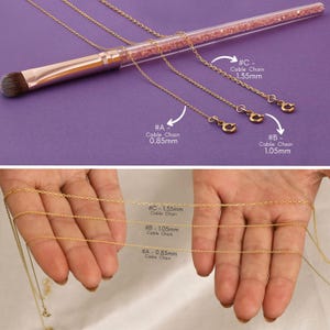 May include: Three gold cable chains of different thicknesses, labeled #A, #B, and #C. The chains are laid out on a pink surface and a hand is holding the chains in a different image. The chains are 0.85mm, 1.05mm, and 1.35mm thick.