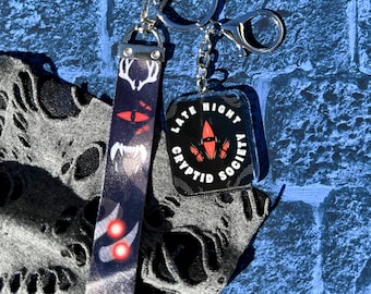 Late Night Cryptid Society wrist lanyard and 2" charm