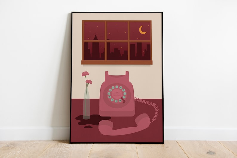 May include: A pink rotary phone with a black dial and a white cord sits on a table with a vase of pink flowers. The phone is in front of a window with a view of a city skyline at night. The window has a brown frame and the wall is a light beige color.