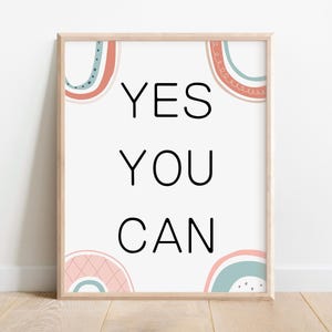 May include: A framed print with a white background and the text "YES YOU CAN" in black. The print is decorated with colorful abstract shapes in pink, blue, and green.
