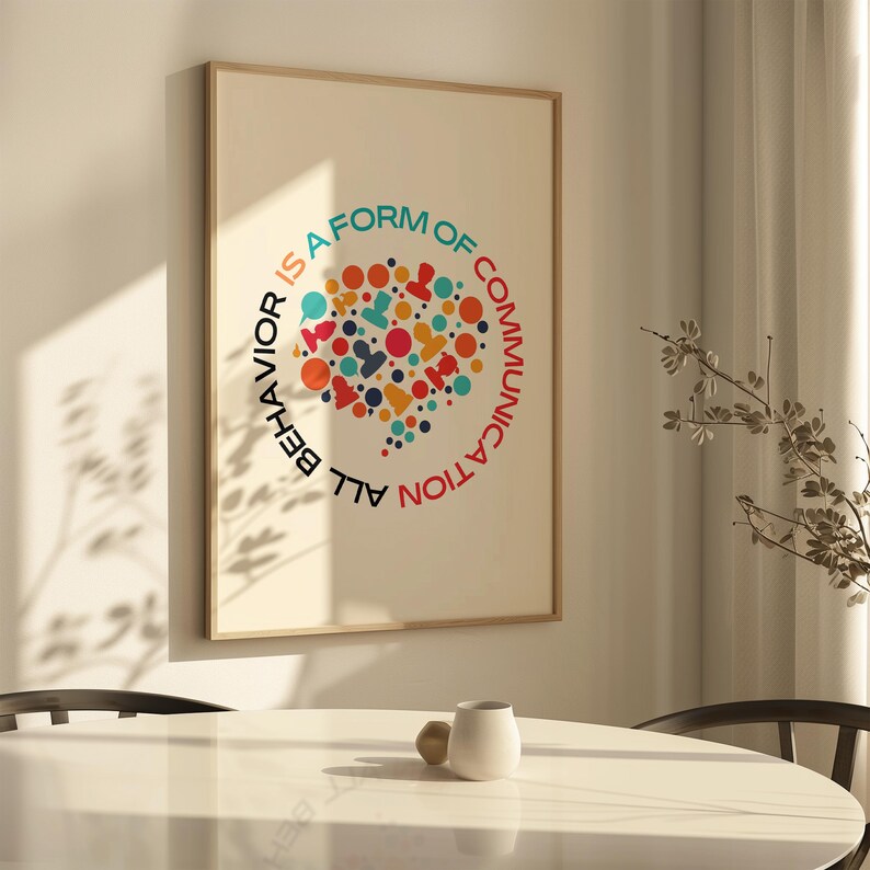 May include: A framed print with a colorful graphic design of a speech bubble with the text "All behavior is a form of communication".