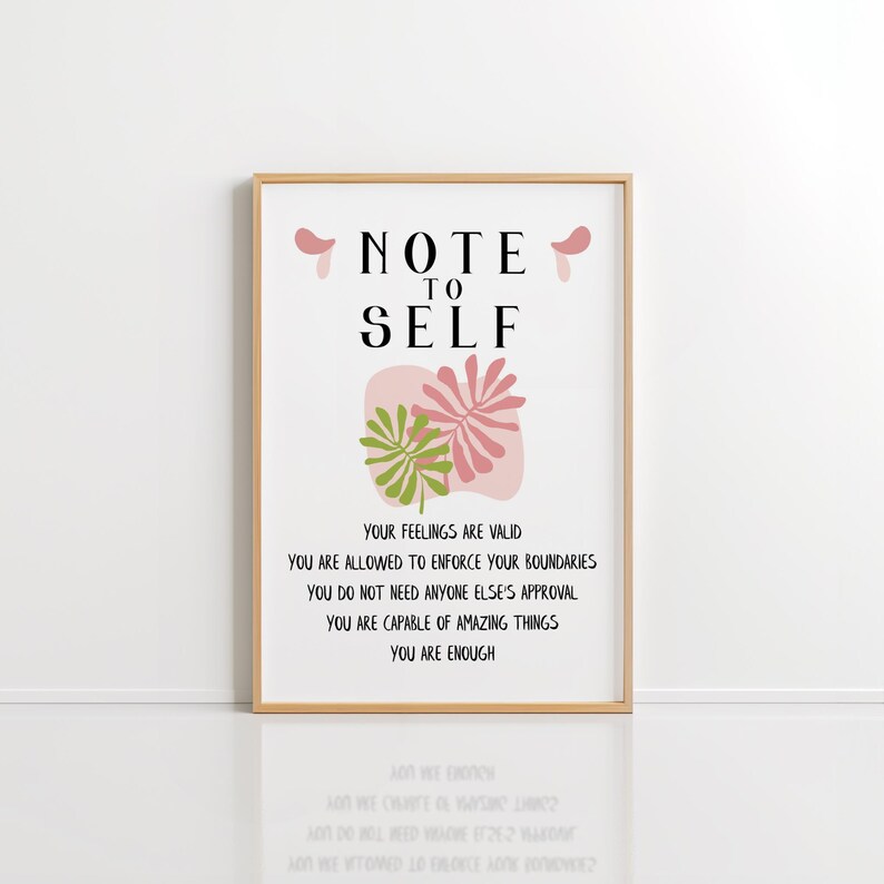 May include: A framed print with a pink and green floral design and the text "NOTE TO SELF" in black. The text below the floral design reads "YOUR FEELINGS ARE VALID YOU ARE ALLOWED TO ENFORCE YOUR BOUNDARIES YOU DO NOT NEED ANYONE ELSE'S APPROVAL YOU ARE CAPABLE OF AMAZING THINGS YOU ARE ENOUGH".