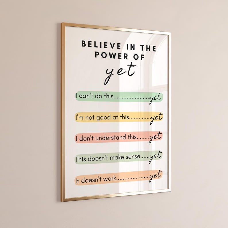 May include: A motivational poster with a gold frame and the text "BELIEVE IN THE POWER OF yet" in black. The poster features five lines of text with the phrase "yet" at the end of each line. The lines are "I can't do this... yet", "I'm not good at this... yet", "I don't understand this... yet", "This doesn't make sense... yet", and "It doesn't work... yet".