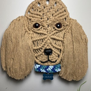 May include: A beige macrame dog wall hanging with brown eyes, a blue and white macrame collar, and a blue bone tag that says "CHARLIE".