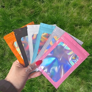 100 bolsas holográficas resellables de colores, de 10 x 15 cm, con cierre multicolor para cosméticos, muestras y regalos.