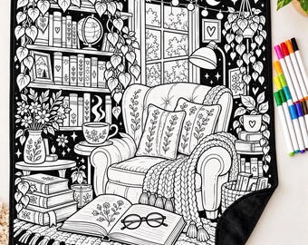 May include: A black and white coloring mat featuring a cozy reading nook with an armchair, bookshelves, a window, hanging plants, and a coffee table. An open book with glasses rests on the floor in front of the chair, accompanied by a set of colorful markers.