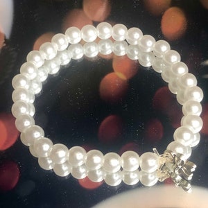 Pulsera casera hecha con perlas y encanto de arco