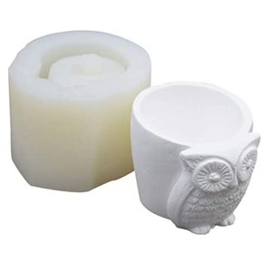 May include: White silicone mold for making a concrete owl planter. The mold is shaped like a round pot with an owl face on the front.