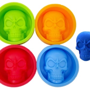 May include: Four silicone skull-shaped molds in green, orange, red, and blue. A single blue skull-shaped mold is also shown.