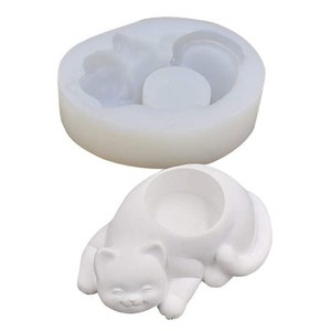 Può includere: Stampo in silicone bianco per realizzare un vaso a forma di gatto. Lo stampo ha uno spazio rotondo e vuoto per il vaso e un design di gatto dettagliato.