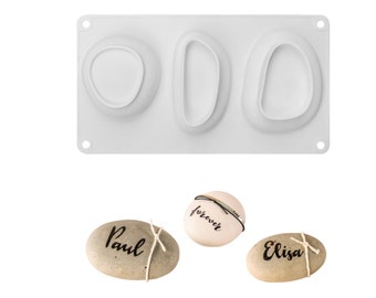 Puede incluir: Un molde de silicona blanco con tres cavidades ovaladas. El molde está diseñado para crear piedras decorativas con las palabras "Paul", "forever" y "Elisa" inscritas en ellas.