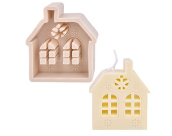Puede incluir: Un molde de silicona beige con forma de casa con un corazón y ventanas. Se muestra una vela blanca con forma de casa con un corazón y ventanas junto al molde.