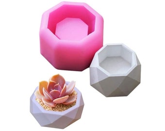 May include: Two geometric concrete planter molds, one pink and one gray, with a finished geometric concrete planter with a succulent plant inside.