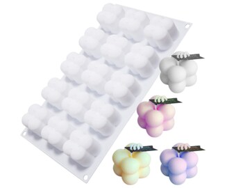 May include: White silicone mould with 16 individual cavities shaped like a cluster of four spheres. The mould is shown with three finished candles in different colours: white, pink, and light blue.