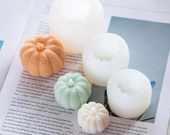Peut inclure: Ensemble de cinq moules en silicone pour réaliser des friandises en forme de citrouille. Les moules sont blancs et présentent un design de citrouille détaillé.
