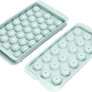 Può includere: Due vassoi per cubetti di ghiaccio in silicone blu chiaro. Un vassoio ha 24 stampi rotondi e l'altro ha 16 stampi a forma di diamante.