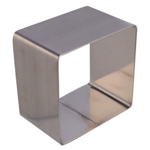 May include: A silver square cake ring, a metal baking tool for creating square cakes.