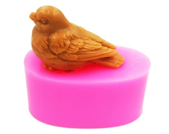 May include: A pink silicone mold shaped like a bird. The bird is brown and has detailed feathers.