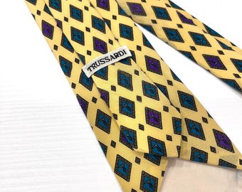 Gravata vintage Trussardi de seda, fabricada na Itália, 100% seda, com estampa geométrica e logotipo de galgo, na cor amarela. Gravata de designer dos anos 90.