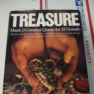 May include: A book cover titled "TREASURE" with the subtitle "Man's 25 Greatest Quests for El Dorado." The cover features a pair of hands holding jewelry, with text that reads "Edited by B.A. Tompkins, As reported in The New York Times."