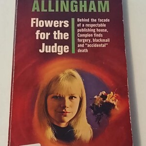 May include: A paperback book cover with a red background and a woman's face in the center. The title is "Flowers for the Judge" by Margery Allingham. The book cover also includes the text "Behind the facade of a respectable publishing house, Campion finds forgery, blackmail and "accidental" death."