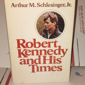 May include: A hardcover book titled "Robert Kennedy and His Times" by Arthur M. Schlesinger, Jr. The book cover is cream-colored with red lettering and a circular portrait of Robert Kennedy. The book is a biography.