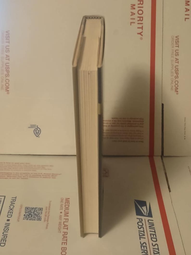 K&ouml;nnte beinhalten: Ein Hardcover-Buch, das vertikal auf seiner Unterkante steht und den Buchr&uuml;cken sowie die cremefarbenen Seitenkanten zeigt. Das Buch hat einen dunkelbraunen Einband und ein schlichtes, klares Design ohne sichtbaren Text oder Grafiken.
