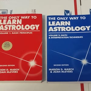 May include: Two red and blue books titled "The Only Way to Learn Astrology" with the volume numbers 1 and 2. Volume 1 is titled "Basic Principles" and volume 2 is titled "Math & Interpretation Techniques". Both books are by Marion D. March & Joan McEvers and are second editions.