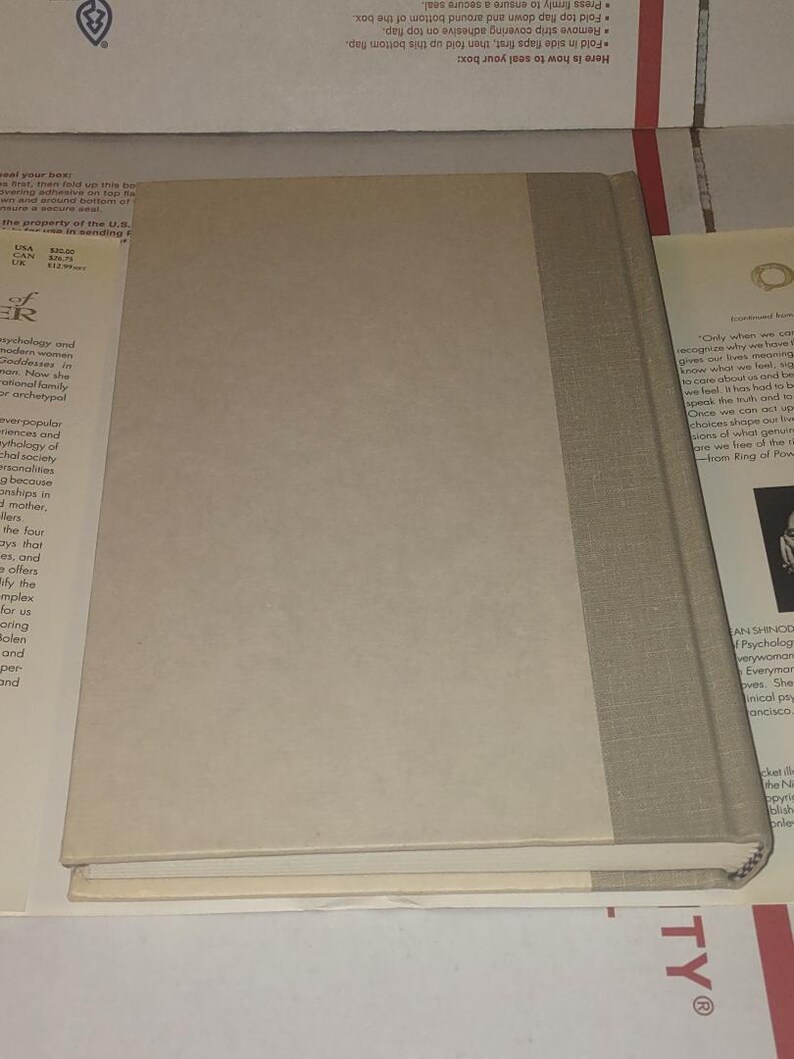 K&ouml;nnte beinhalten: Ein gebundenes Buch mit hellbeigem Vorderdeckel und einem Buchr&uuml;cken aus strukturiertem grauem Stoff. Das Buch liegt flach und zeigt den Vorderdeckel sowie den Buchr&uuml;cken, w&auml;hrend die R&uuml;ckseite nicht sichtbar ist. Schlichtes, einfarbiges Design.