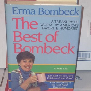 May include: A hardcover book titled "The Best of Bombeck" by Erma Bombeck. The cover features a photo of the author holding a mug, with text including "A Treasury of Works by America's Favorite Humorist" and quotes.