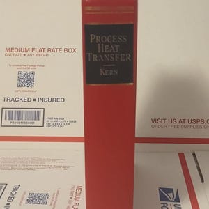 May include: A red hardcover book titled "Process Heat Transfer" by Kern. The book's spine features black lettering and the McGraw-Hill Book Company logo. The book is standing upright on a white surface, likely inside a USPS Priority Mail box.
