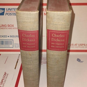 May include: Two hardback books with brown covers and red spines. The books are titled "Charles Dickens His Tragedy and Triumph".