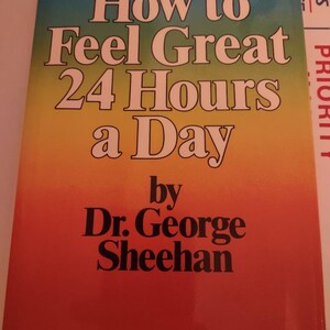 May include: A book cover with a rainbow gradient background. The title is "How to Feel Great 24 Hours a Day" by Dr. George Sheehan.