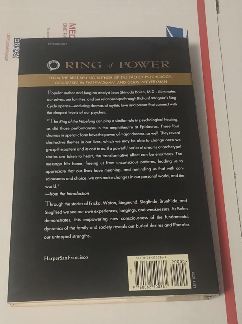 K&ouml;nnte beinhalten: Die R&uuml;ckseite des Buches Ring of Power von Jean Shinoda Bolen, M.D. Der schwarze Einband zeigt goldenen Text, eine Zusammenfassung der psychologischen Themen des Buches, den Verlag HarperSanFrancisco und einen Strichcode mit ISBN 0-06-250086-4.