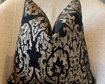 May include: Black and gold patterned throw pillow with a damask design.