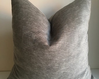 May include: A gray corduroy pillow with a ribbed texture. The pillow is square and has a simple design.