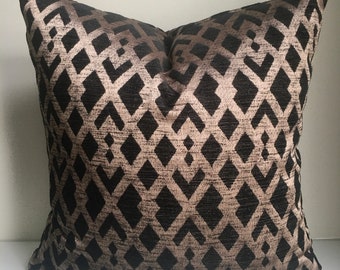 May include: A black and gold geometric patterned throw pillow. The pillow has a diamond pattern with a subtle sheen.